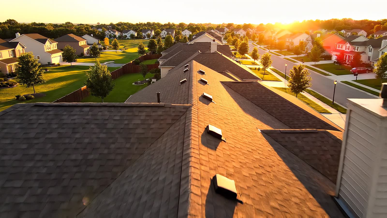 Aerial drone over a residential roof at golden hour